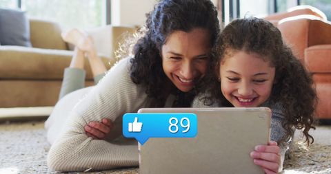Mother and Daughter Smiling While Using Tablet Together