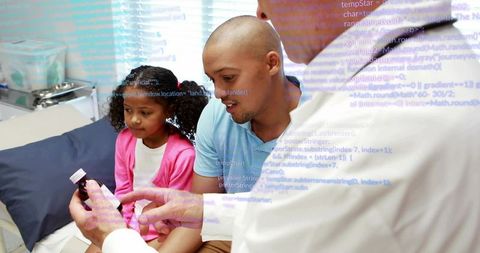 Pediatric consultation with doctor explaining medication to parent and child in clinic room
