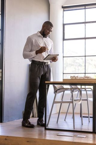 Professional Architect Analyzing Tablet Near Scale Models in Modern Studio