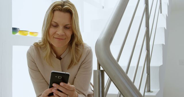 Smiling Woman Using Smartphone at Home on Staircase - Download Free Stock Images Pikwizard.com