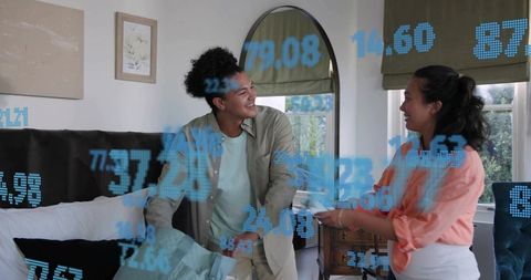 Young couple checking smart home data on tablet with floating blue digital overlays