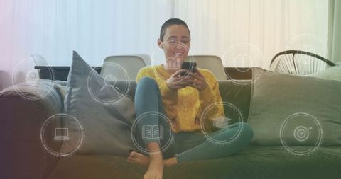 Smiling Woman Relaxing on Sofa with Phone Surrounded by Digital Icons