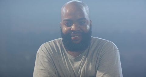 African american man smiling and sweating after workout in misty blue studio portrait