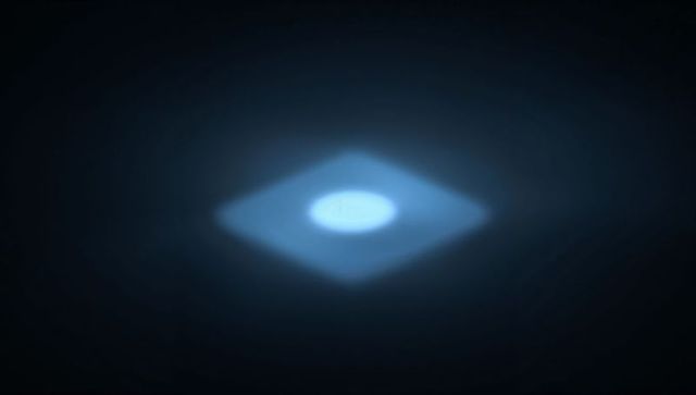 Glowing rhombus hovering with radiant circular core and soft blue halo