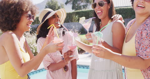 Diverse Women Celebrating with Drinks by Summer Poolside