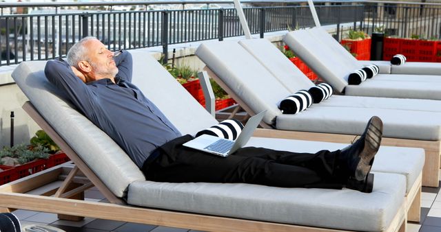 Senior Man Relaxing on Rooftop Sun Lounger with Laptop - Download Free Stock Images Pikwizard.com