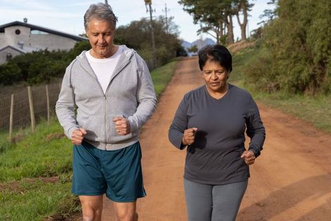 Couple Jogging Down Rural Road Enjoying Active Lifestyle