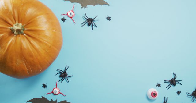 Close up view of pumpkin and halloween toys against blue background. halloween festivity and celebration concept