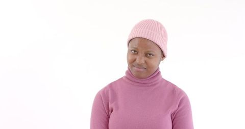 Woman in pink sweater and beanie shows skepticism