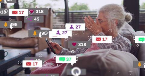 Senior woman reacting to social media notifications on smartphone in cozy living room
