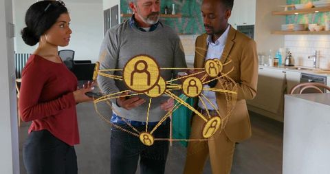 Team collaborating around holographic network visualization in modern office kitchen