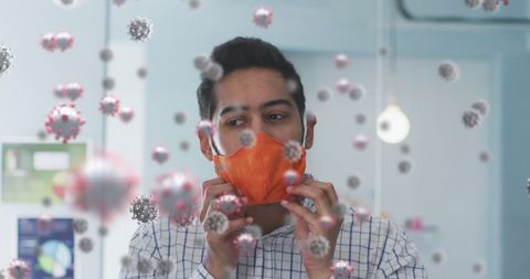 Man Adjusting Mask with COVID-19 Particles in Office Environment - Download Free Stock Images Pikwizard.com