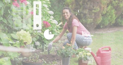 Smiling female gardener kneeling planting colorful flowers in backyard with trowel and watering can