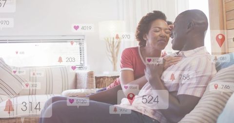 Couple sharing intimate moment on sofa with social media notification overlays