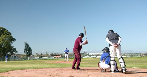 Baseball game action with batter preparing at home plate
