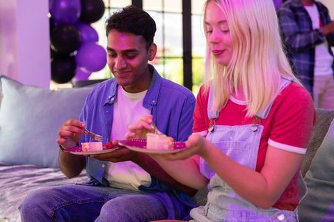 Young friends enjoying cake at home celebration