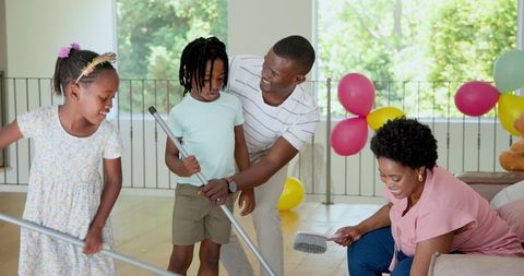 Happy Family Cleaning Together at Home with Smiles