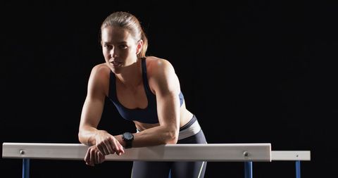 Focused Female Athlete Leaning on Hurdle in Sports Studio - Download Free Stock Images Pikwizard.com