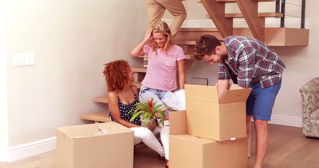 Friends Having Fun Moving into New Home with Boxes and Plants - Download Free Stock Images Pikwizard.com