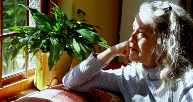 Mature Woman Relaxing Near Window with Sunlight - Download Free Stock Images Pikwizard.com