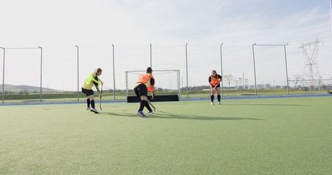 Female field hockey practice on synthetic turf field
