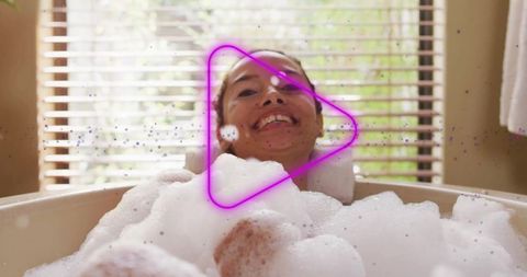 Mid-Adult Woman Relaxing in Bath with Foam and Neon Icon Overlay
