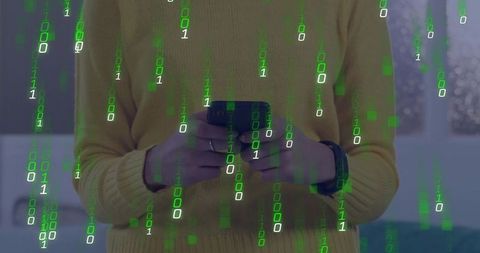 Woman holding smartphone with binary code overlay wearing mustard sweater and smartwatch