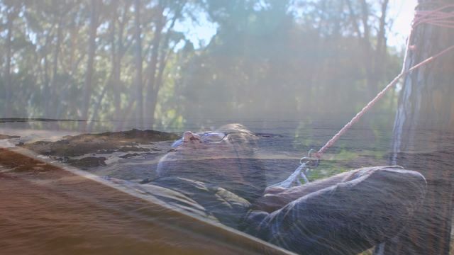 This creative double exposure shows a male hiker peacefully resting, overlaying a tranquil forest landscape. This video represents harmony with nature, tranquility, and relaxation in the outdoors. Ideal for concepts in holiday promotions, adventure gear, wellness retreats, and environmental campaigns promoting meditative and reflective themes.