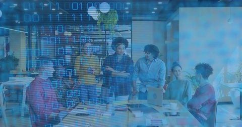 Diverse team collaborating around laptop in modern workspace with binary code overlay