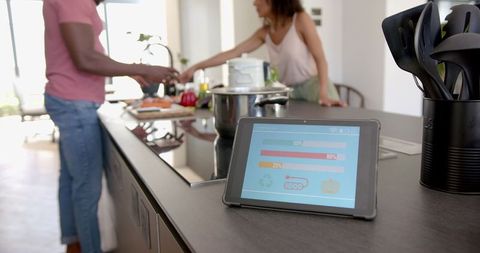 Couple Cooking in Modern Kitchen Using Tablet for Recipes