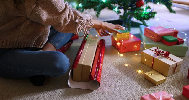 Person Wrapping Christmas Presents by the Tree - Download Free Stock Images Pikwizard.com