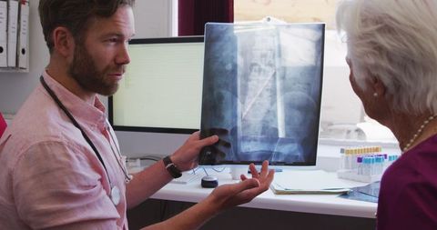 Doctor Explains X-Ray to Senior Woman During COVID-19 Pandemic