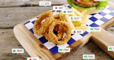 Crispy onion rings featuring burger and social media badges on rustic wooden board