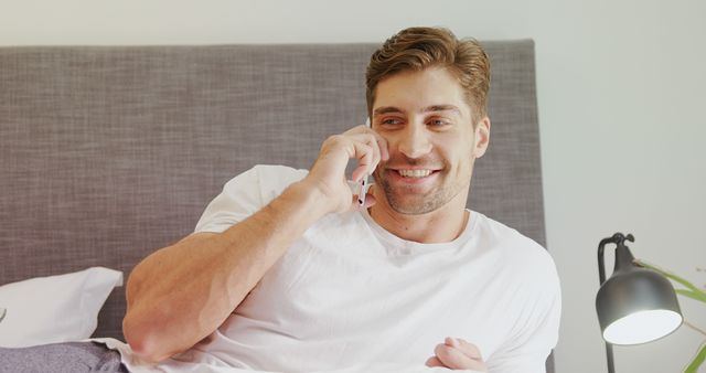 Smiling Man Talking on Smartphone While Relaxing on Bed - Download Free Stock Images Pikwizard.com