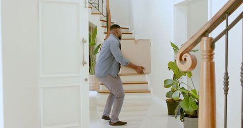 Man Unpacking Moving Boxes in Bright Modern Home Entryway
