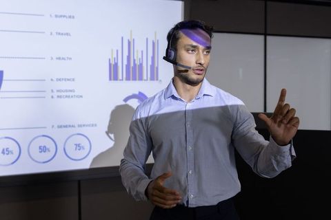 Businessman presenting data analysis with projector and headset