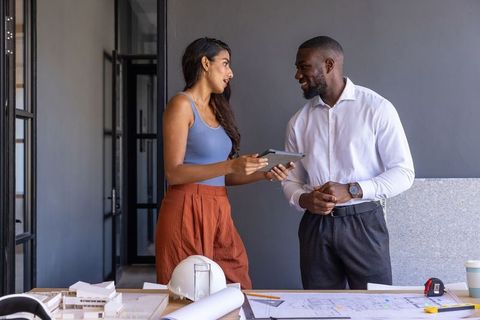 Architects Discussing Plans with Scale Model in Modern Office