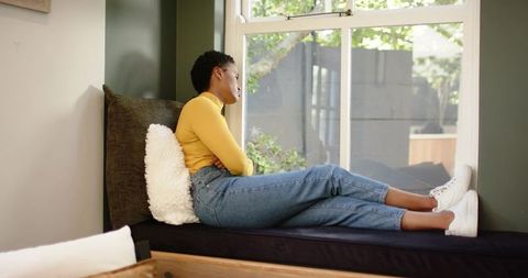 Relaxed Woman Gazing Out Window from Cozy Nook