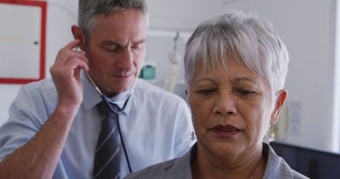 Doctor Examining Senior Woman with Stethoscope in Medical Clinic