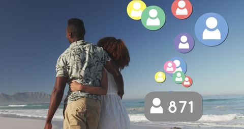 Couple Strolling Along Beach with Social Media Networking Icons