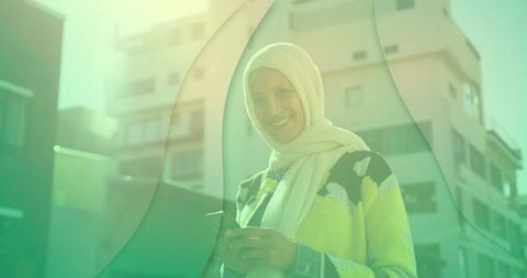 Stylish middle eastern woman with smartphone in urban plaza