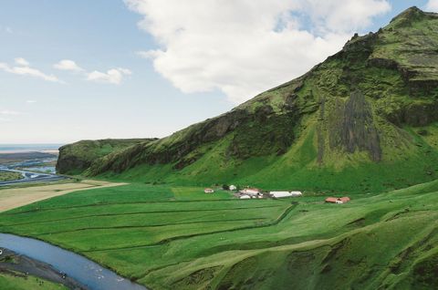 Icelandic Green Valley Farm Nestling Below Mossy Cliff Overlooking Meandering River