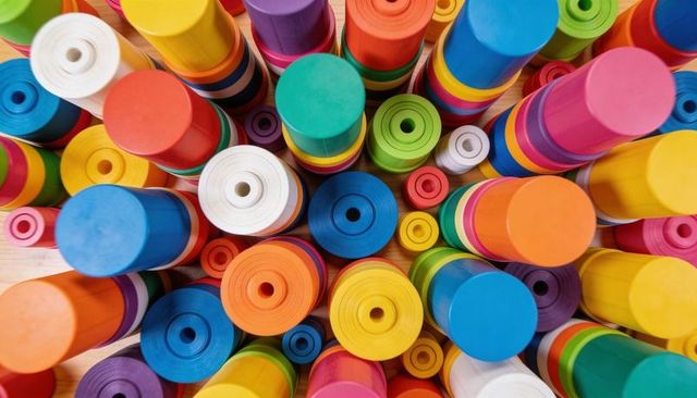 Colorful wooden stacking cylinders creating geometric top-down pattern for kids play