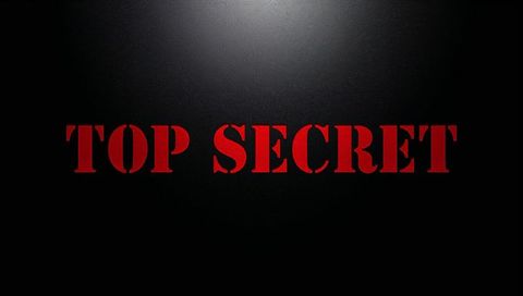 Red top secret stencil on black textured backdrop with dramatic spotlight