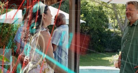 Backyard pool party friends chatting by umbrellas in floral sundress with neon light streaks