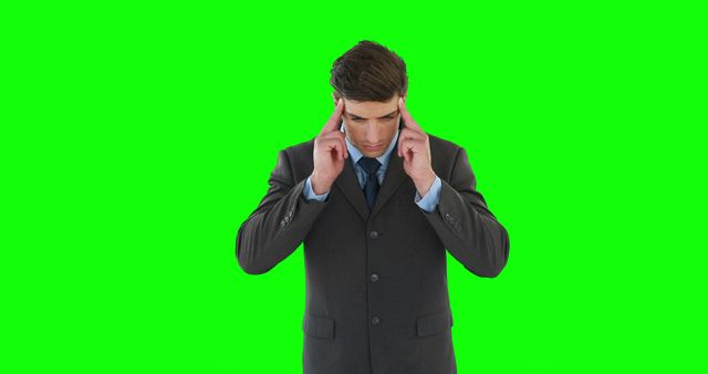 Businessman touching temples showing signs of stress or deep concentration. Could be used in articles about work stress, mental health in the workplace, business decision-making, or headache solutions.