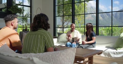 African american friends chatting in modern lounge with mountain view and natural light