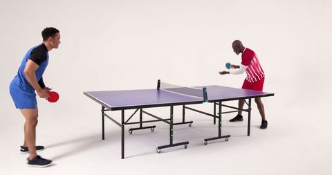 Two Male Athletes Competing in Table Tennis Match