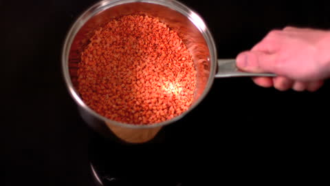 Slow Motion Red Lentils Shaken in Silver Pot
