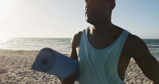 Man Holding Yoga Mat at Beach During Sunset - Download Free Stock Images Pikwizard.com